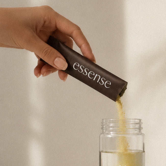 Pouring a Protocol 01 sachet into the Essense glass water bottle · the 7am ritual